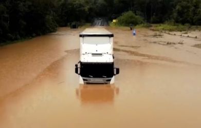 Motorista de carreta fica ilhado ao tentar passar por trevo inundado